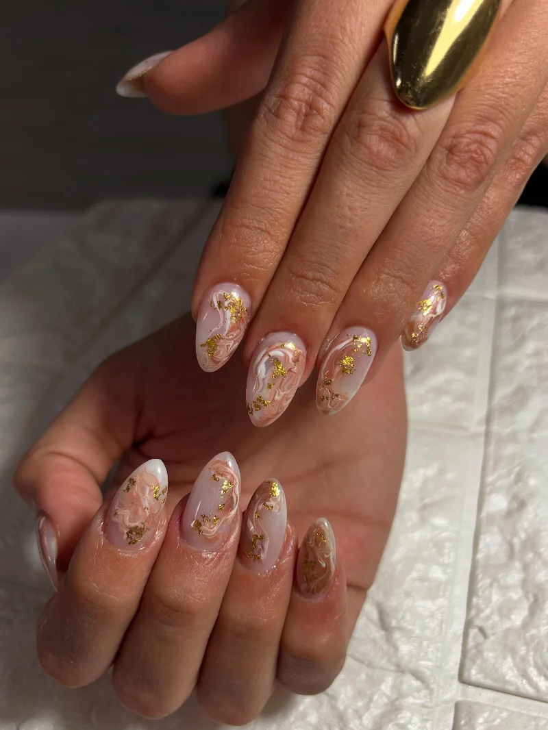 Manicura nude con mármol y detalles dorados